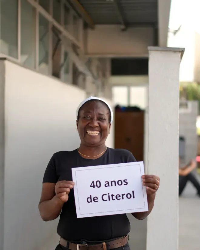 Colaboradora da Citerol segurando um cartaz com 40 anos de Citerol