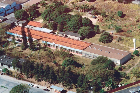 A fábrica antiga da Citerol vista do alto, com telhados vermelhos entre árvores